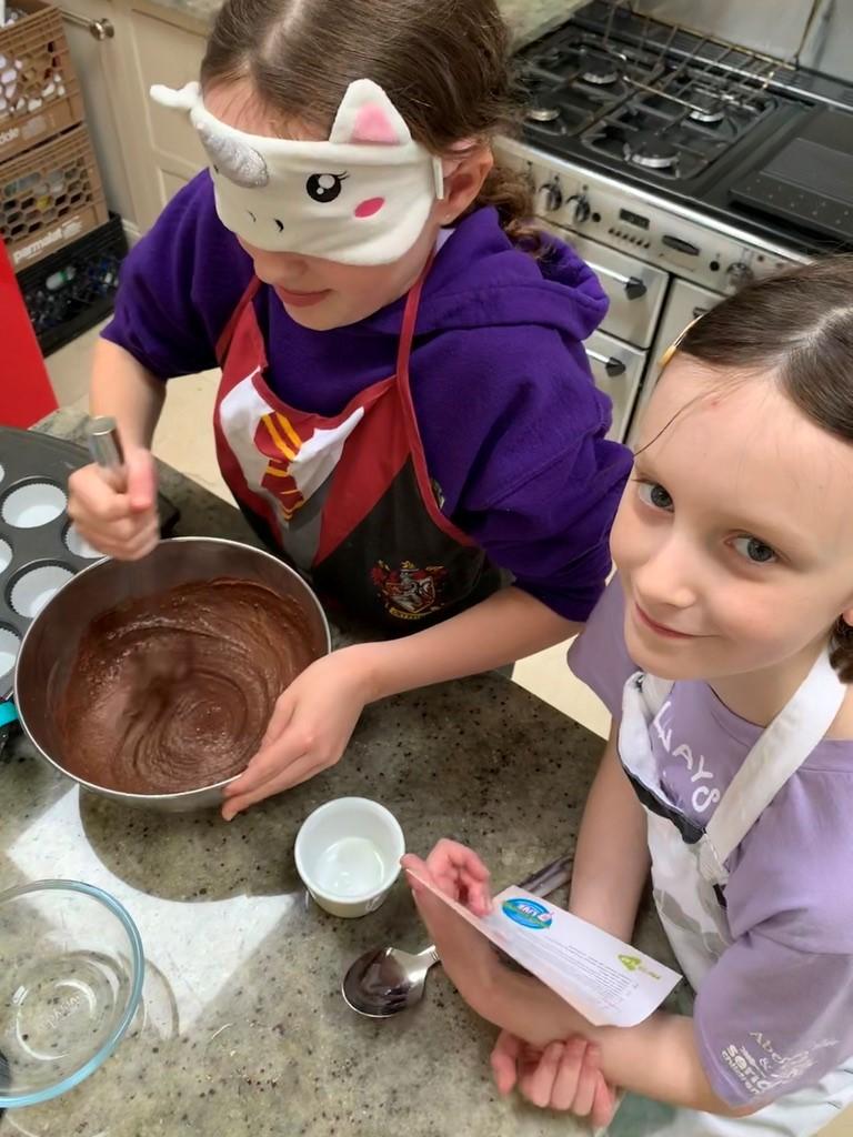 Two girls working on a baking recipe with Barretstown